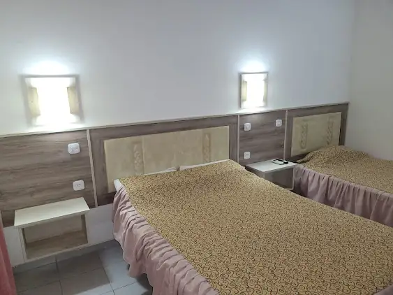 Interior de habitación de Hotel Le Park en Machagai con dos camas y mobiliario de madera